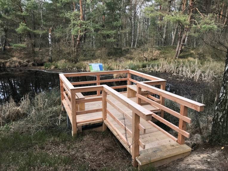 Holzsteg und Holzplattform an einem Gewässer