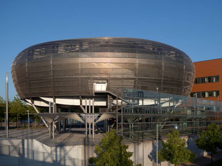 Round structure, in the background some building.